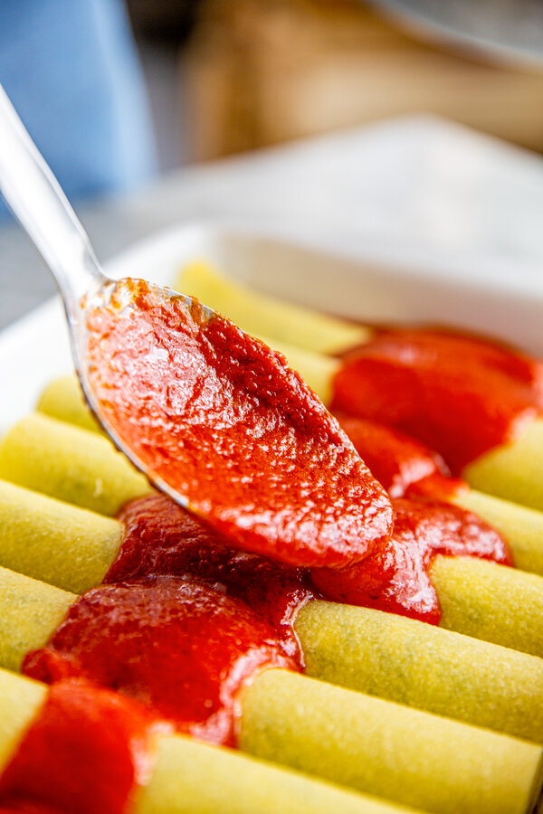 Versa la salsa sui cannelloni